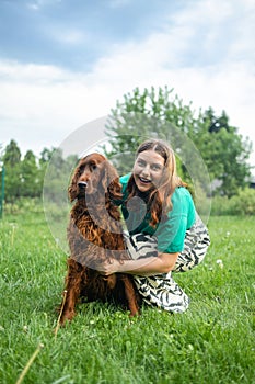 Happy caucasian woman hugging Irish Setter dog pet cute adorable red dog friendly closeup closing eyes funny animals