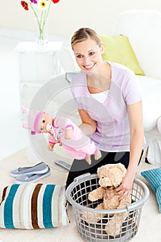 Happy caucasian woman putting toys into a basket