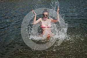 Happy caucasian woman swimming in lake and splashing. summer time. fun outdoors