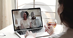 Happy caucasian woman video calling african friends couple on laptop