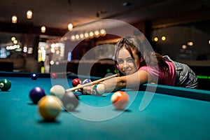 Happy caucasian woman wear casual cloth playing a game of billiards