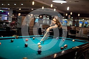 Happy caucasian woman wear casual cloth playing a game of billiards