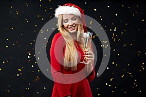 Happy celebrated woman holding shampagne glass, over black shimmering wall.