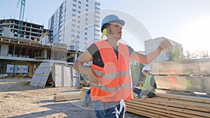 Happy and charismatic Afro American guy construction worker dancing funny at the lunch time beside his colleagues from