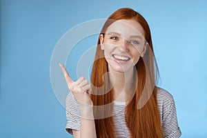 Happy charismatic redhead laughing young girl having fun looking carefree talking discussing new product sale pointing