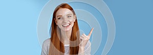 Happy charismatic redhead laughing young girl having fun looking carefree talking discussing new product sale pointing