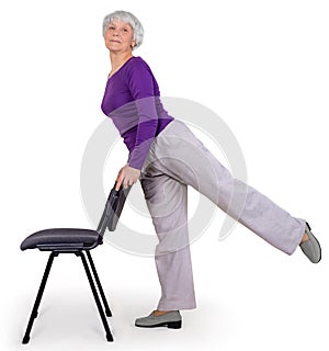 Happy charming beautiful elderly woman doing exercises at home on a chair. Workout gymnastics for health. On a white background