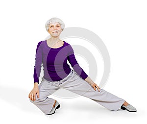 Happy charming beautiful elderly woman doing exercises while working out playing sports