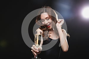 Happy charming young woman drinking champagne