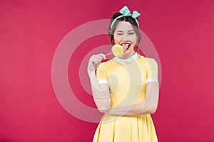 Happy charming young woman eating sweet lollipop and winking