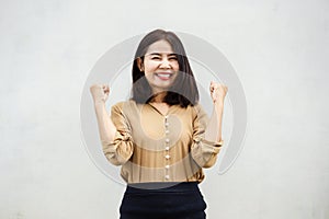 Happy cheerful Asian business woman smiling over grey wall background