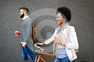 Happy cheerful businesswoman going to work by bicycle