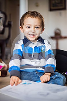 Happy cheerful child drawing at home