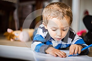 Happy cheerful child drawing at home. Creativity concept