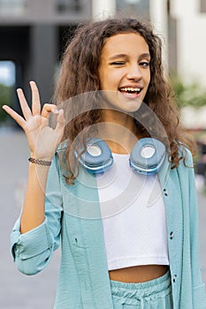 Happy cheerful child girl showing ok gesture, positive like sign, approve something good, celebrate