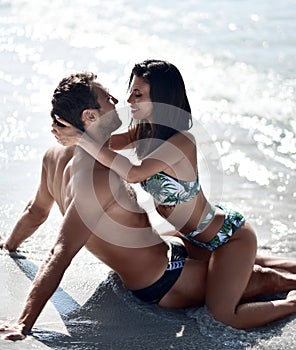 Happy cheerful couple kissing hugging in the sea together. Romantic vacation, honeymoon love