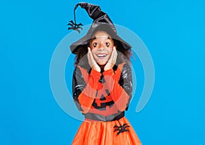 Happy cheerful ethnic girl in costume pumpkin smiles in glad while celebrates Halloween on blue background