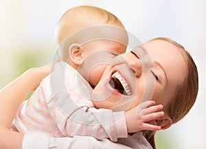 Happy cheerful family. Mother and baby kissing