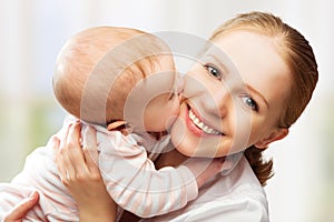 Happy cheerful family. Mother and baby kissing