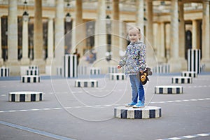 Happy cheerful girl running in Palais Royale in Paris