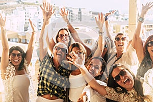 Happy and cheerful group of women friends together dancing and having fun on the rooftop at home - people celebrating together