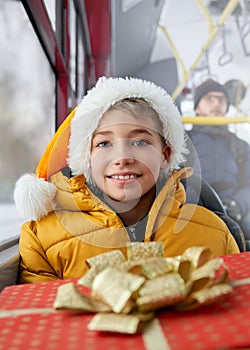 Happy, cheerful kid traveling by public transport, bus during Christmas, winter holidays.
