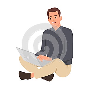 Happy cheerful man working on laptop computer while sitting on the floor. Freelancer working at home