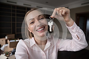 Happy cheerful new homeowner girl holding, showing keys