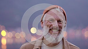 Happy cheerful older man traveler standing outdoors. Close up portrait