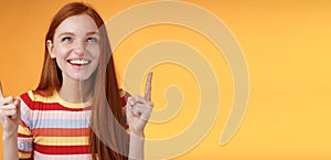 Happy cheerful redhead girl having fun amusement park laughing joyfully pointing look up index fingers upwards enjoy