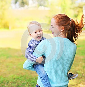 Happy cheerful smiling mother and son child having fun outdoors