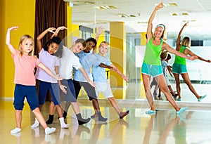 Preteen dancers practicing dance routine with female choreograph