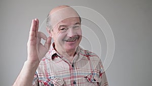 Happy, cheerful, smiling, senior hispanic man showing OK sign