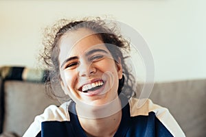 Happy cheerful teenager rejoicing at positive news or birthday gift, looking at camera with joyful and charming smile