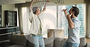 Happy cheerful young couple dancing to music together