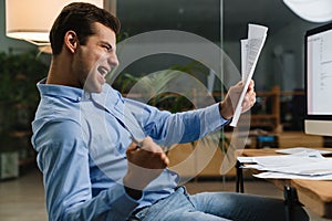 Happy cheerful young man celebrating success