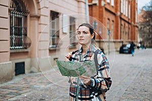 Happy cheerful young woman with map walking on city street, Urban lifestyle concept. Traveler. Attractive female tourist