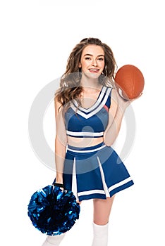 Happy cheerleader girl in blue uniform holding rugby ball and pompom isolated on white