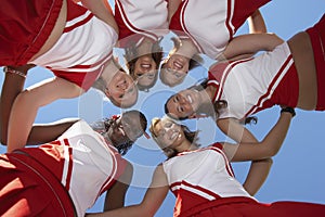 Happy Cheerleaders Forming A Huddle