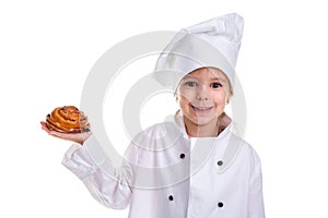 Happy chef girl in a cap cook uniform, holding the bun in the right hand. Looking at the camera