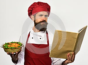 Happy chef holding paper menu book on white background.