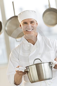 Happy Chef Holding Utensil In Commercial Kitchen