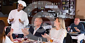 Happy chef listens to praise of food in restaurant