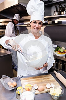 Happy chef whisking bowl of eggs