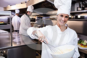 Happy chef whisking bowl of eggs