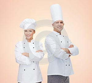 Happy chefs or cooks couple over beige background