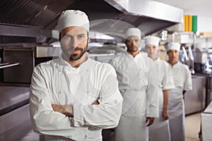 Happy chefs team standing together in commercial kitchen