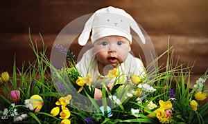 Happy child baby dressed as the Easter bunny rabbit on the grass