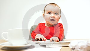 Happy child baby girl toddler sitting with keyboard of computer isolated on a white background