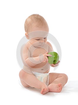 Happy child baby toddler sitting in diaper with green apple